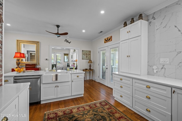 kitchen featuring stainless steel dishwasher, crown molding, a ceiling fan, light countertops, and a sink