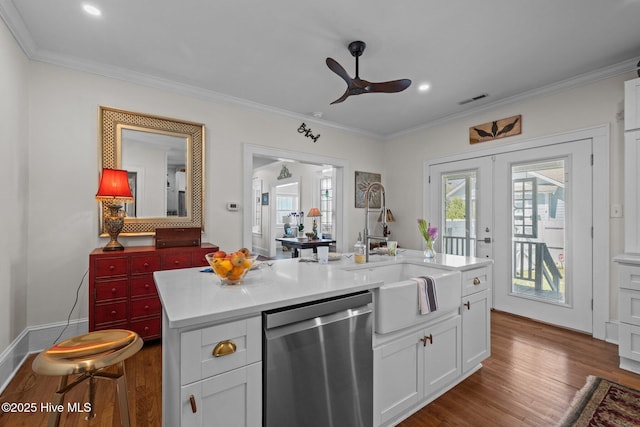 kitchen featuring stainless steel dishwasher, crown molding, a sink, and dark wood-type flooring