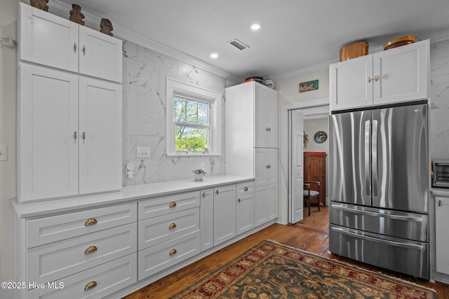 kitchen featuring visible vents, freestanding refrigerator, white cabinetry, and wood finished floors
