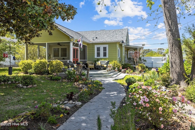 bungalow-style house featuring fence and a ceiling fan
