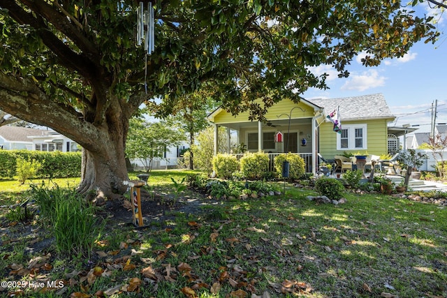 view of front facade with a patio, fence, a ceiling fan, and a front lawn