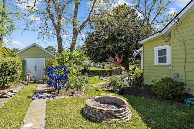 view of yard with an outbuilding, an outdoor fire pit, and a shed