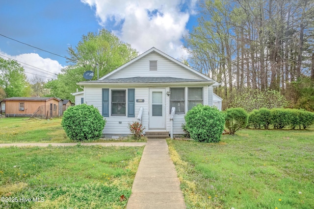 bungalow-style house featuring a front yard and a shingled roof