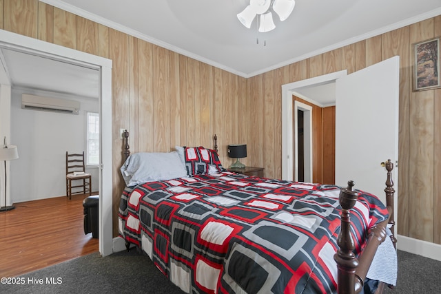 bedroom with crown molding, an AC wall unit, ceiling fan, and wood walls
