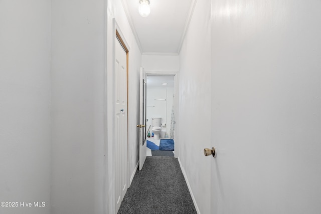 hallway with crown molding, baseboards, and carpet