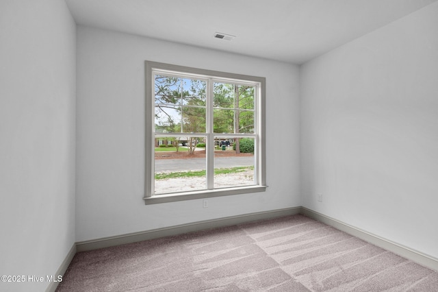 unfurnished room featuring carpet floors, baseboards, and visible vents