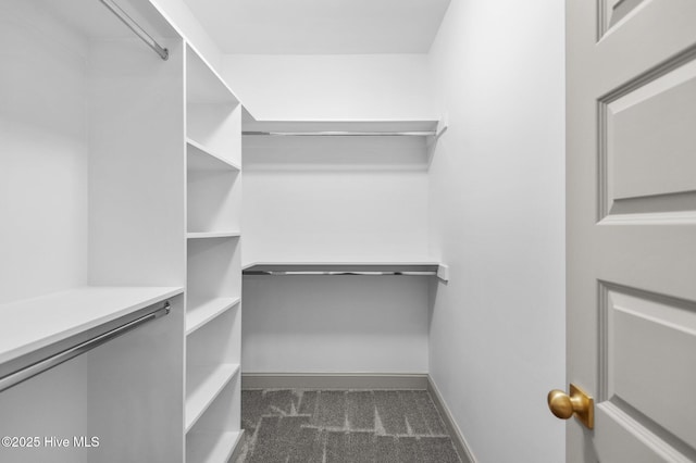 spacious closet featuring dark carpet