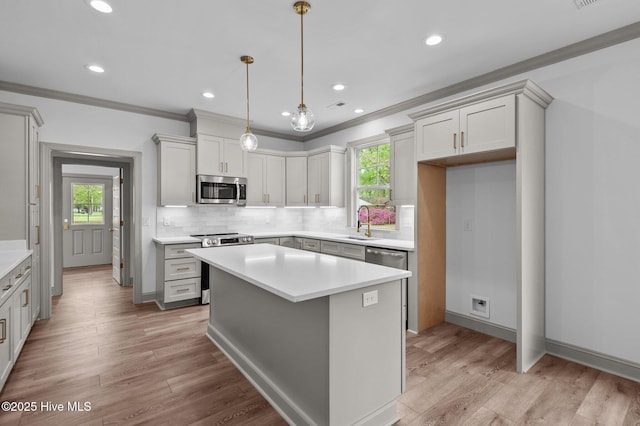 kitchen with crown molding, stainless steel appliances, decorative backsplash, and a sink
