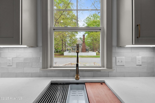 details featuring light countertops and tasteful backsplash
