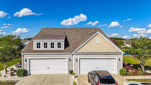 view of front facade with a shingled roof, a garage, and driveway