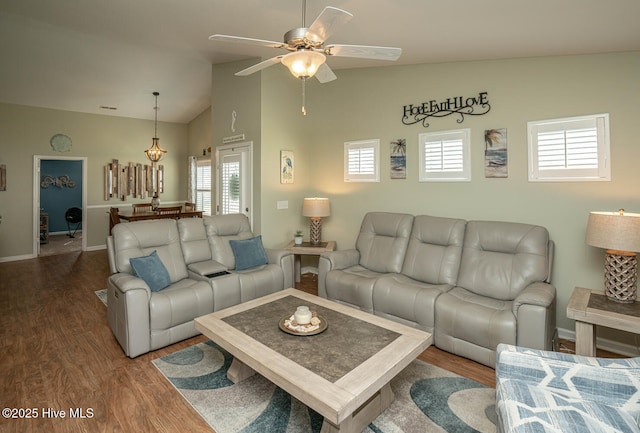 living room with ceiling fan, high vaulted ceiling, wood finished floors, and baseboards