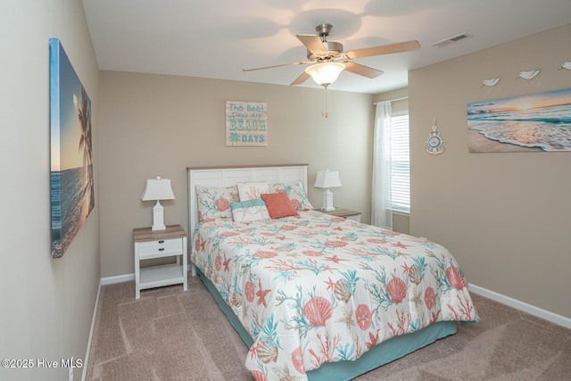 carpeted bedroom with visible vents, baseboards, and a ceiling fan