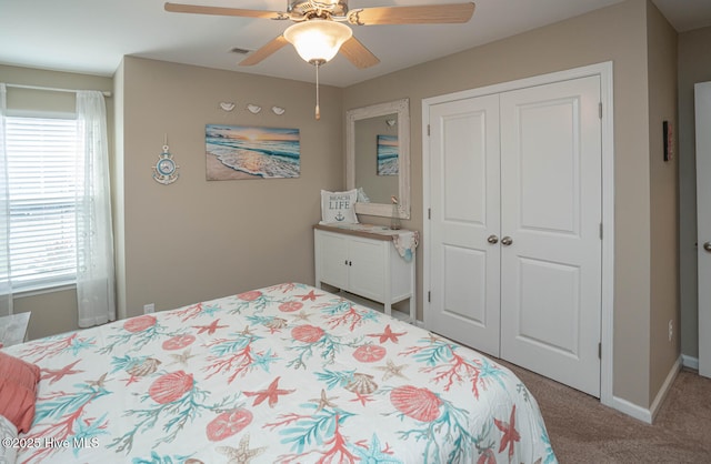 carpeted bedroom with a closet, ceiling fan, multiple windows, and visible vents