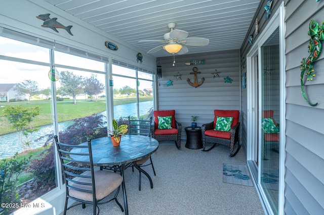 sunroom / solarium with a water view and ceiling fan