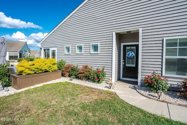 property entrance featuring a lawn