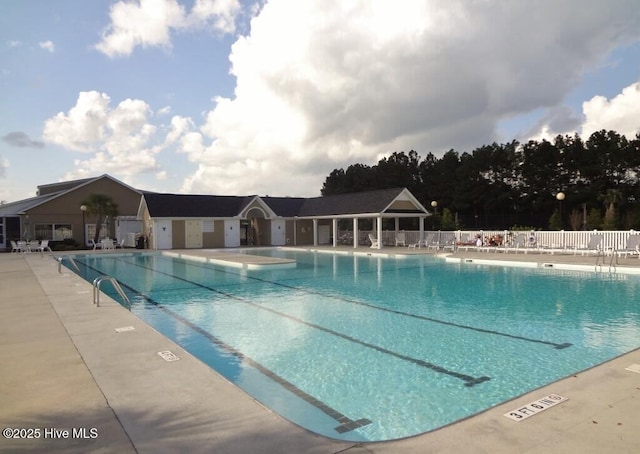 community pool with a patio and fence