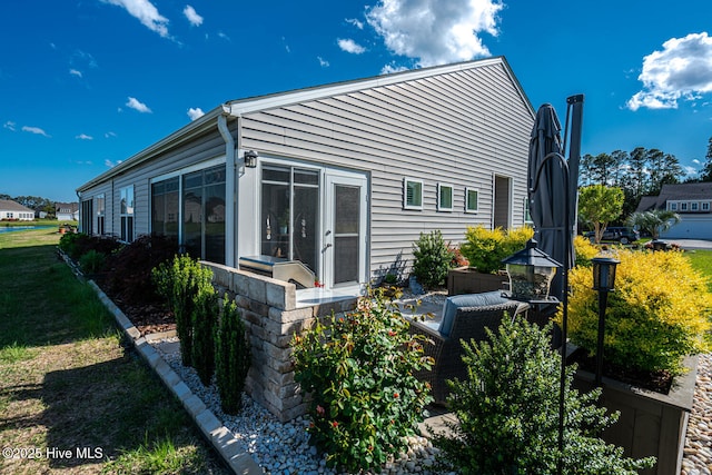 rear view of house featuring a sunroom