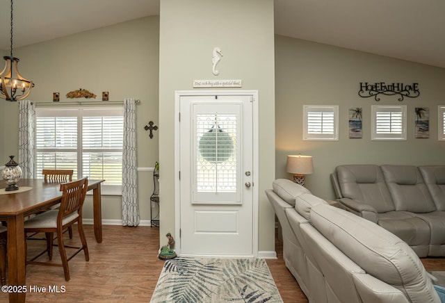 entryway with a chandelier, wood finished floors, and baseboards