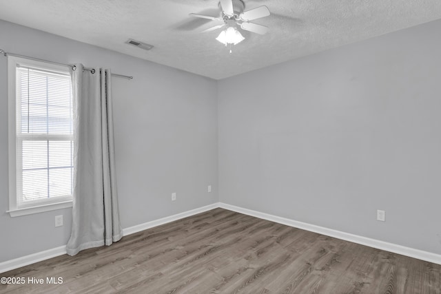unfurnished room with baseboards, a textured ceiling, a ceiling fan, and wood finished floors