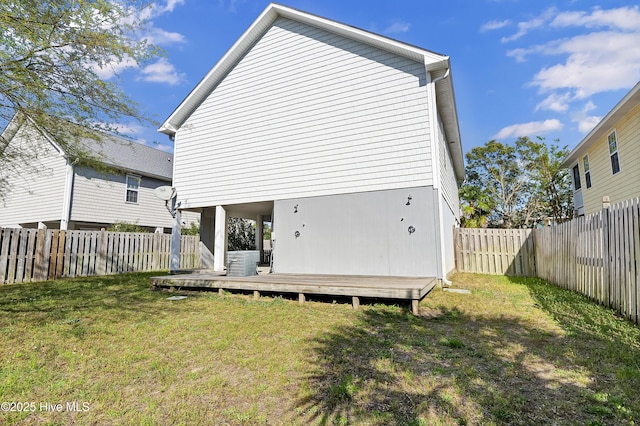 rear view of house with a fenced backyard and a lawn