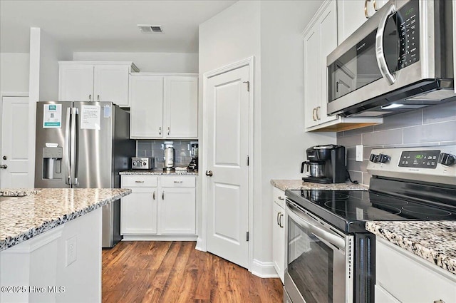kitchen featuring tasteful backsplash, white cabinets, visible vents, and appliances with stainless steel finishes
