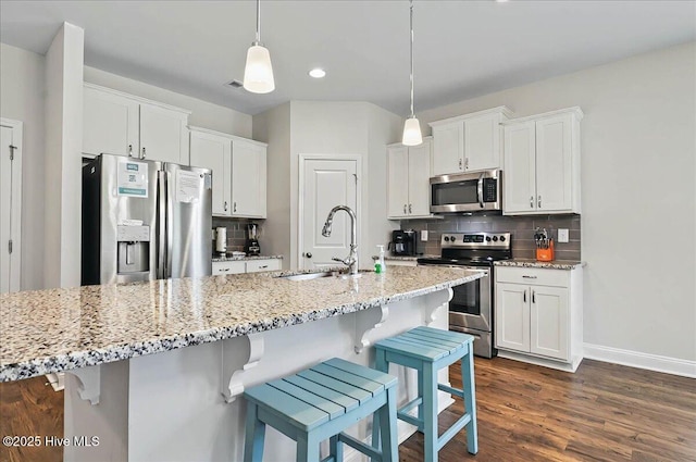 kitchen featuring a sink, tasteful backsplash, white cabinetry, and appliances with stainless steel finishes
