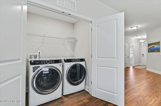 laundry area featuring dark wood finished floors, laundry area, visible vents, and independent washer and dryer