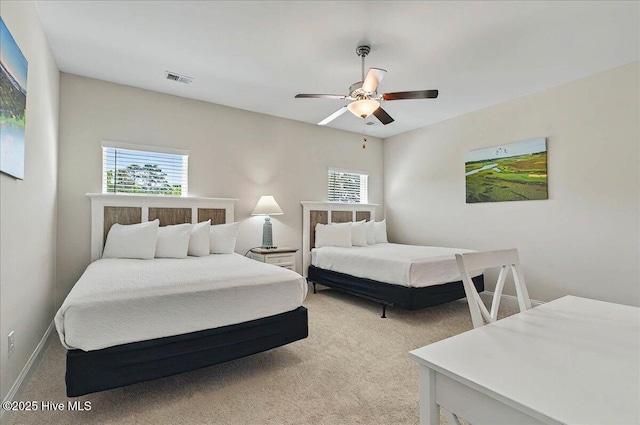 bedroom featuring light colored carpet, baseboards, ceiling fan, and visible vents
