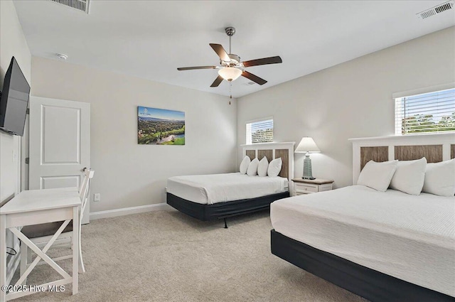 bedroom featuring baseboards, multiple windows, visible vents, and light colored carpet