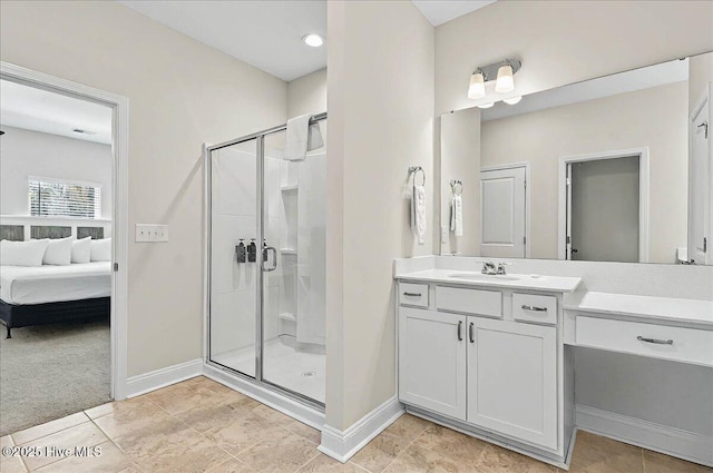 ensuite bathroom featuring a stall shower, vanity, ensuite bathroom, and baseboards