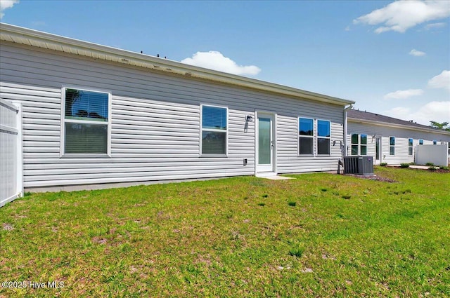 rear view of property with a yard and cooling unit