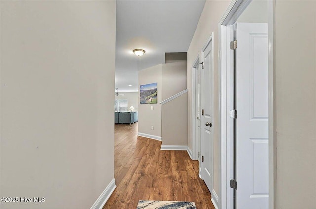 corridor with wood finished floors and baseboards