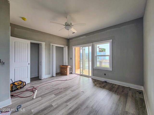 706 N New River Dr, Surf City, NC 28445 - unfurnished bedroom featuring access to exterior, baseboards, multiple closets, and wood finished floors