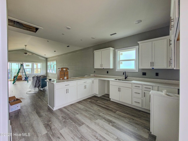 706 N New River Dr, Surf City, NC 28445 - kitchen featuring white cabinets, a sink, open floor plan, light wood-type flooring, and a peninsula