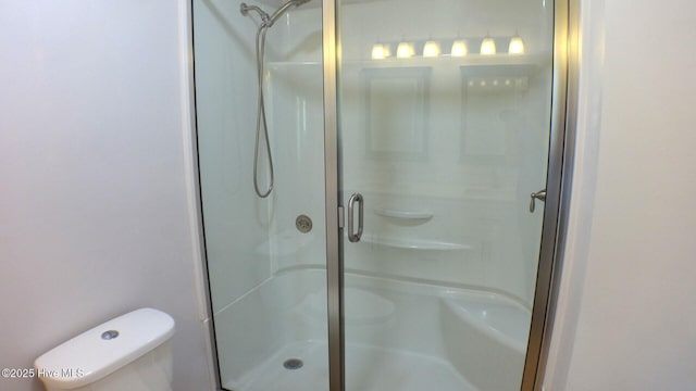 bathroom with a shower stall and toilet