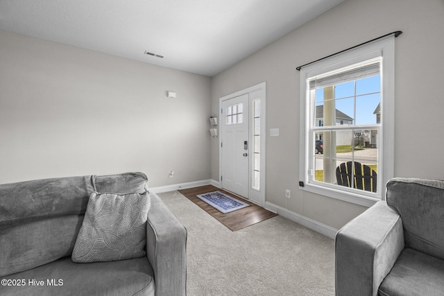 carpeted living room with baseboards and visible vents