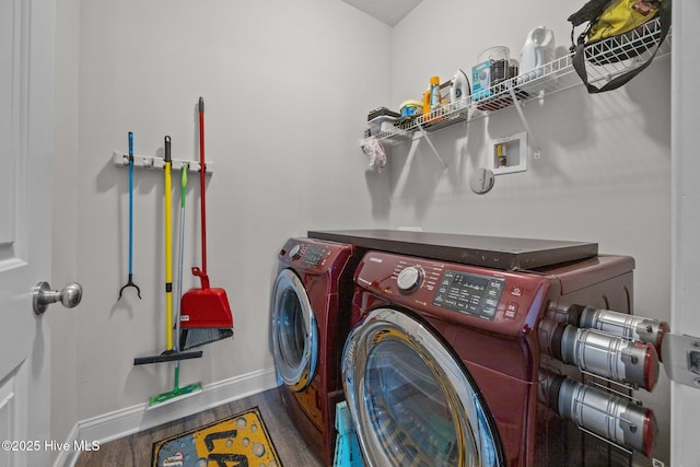 laundry area featuring washer and dryer, laundry area, baseboards, and wood finished floors