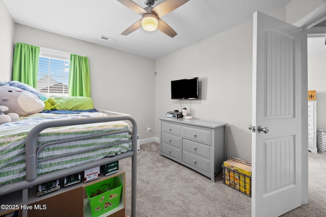 bedroom featuring light colored carpet, a ceiling fan, baseboards, and visible vents