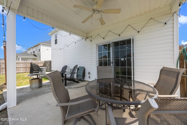 view of patio / terrace with a ceiling fan, fence, and outdoor dining space
