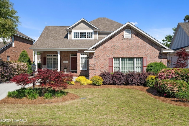 423 Black Diamond Dr, Wilmington, NC 28411 - view of front of home with brick siding, a front lawn, and a shingled roof