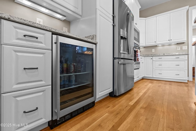 423 Black Diamond Dr, Wilmington, NC 28411 - interior space featuring light wood-type flooring, appliances with stainless steel finishes, and beverage cooler