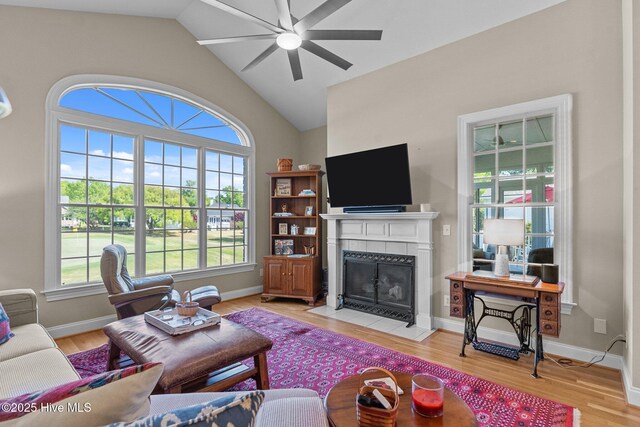 423 Black Diamond Dr, Wilmington, NC 28411 - living room featuring baseboards, light wood-type flooring, lofted ceiling, a tile fireplace, and ceiling fan