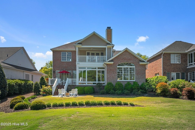 423 Black Diamond Dr, Wilmington, NC 28411 - back of house featuring a lawn, a chimney, brick siding, and a balcony
