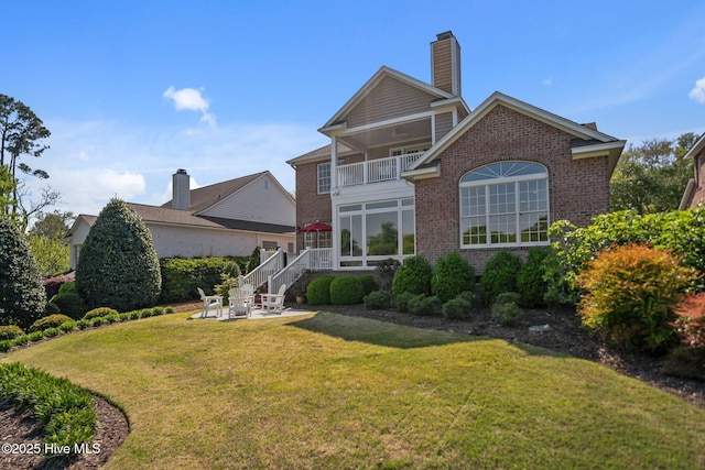423 Black Diamond Dr, Wilmington, NC 28411 - rear view of house featuring a yard, a patio, brick siding, a chimney, and a balcony
