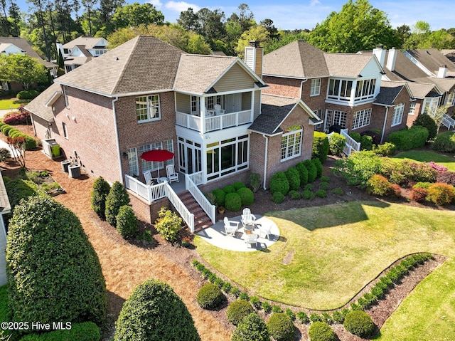 423 Black Diamond Dr, Wilmington, NC 28411 - back of property with a yard, brick siding, a balcony, and a chimney