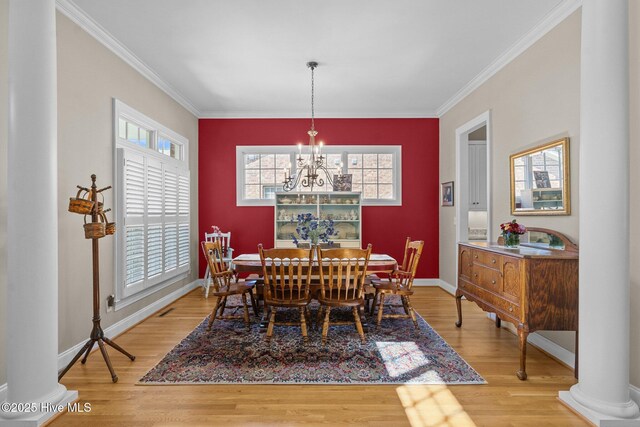 423 Black Diamond Dr, Wilmington, NC 28411 - dining area featuring plenty of natural light, light wood-type flooring, ornate columns, and crown molding
