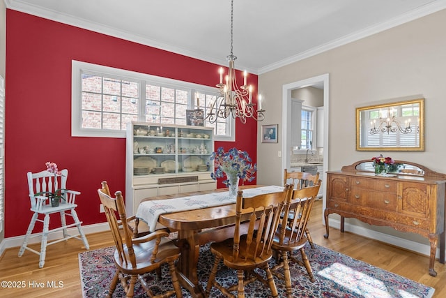423 Black Diamond Dr, Wilmington, NC 28411 - dining area featuring ornamental molding, light wood-style flooring, a notable chandelier, and baseboards