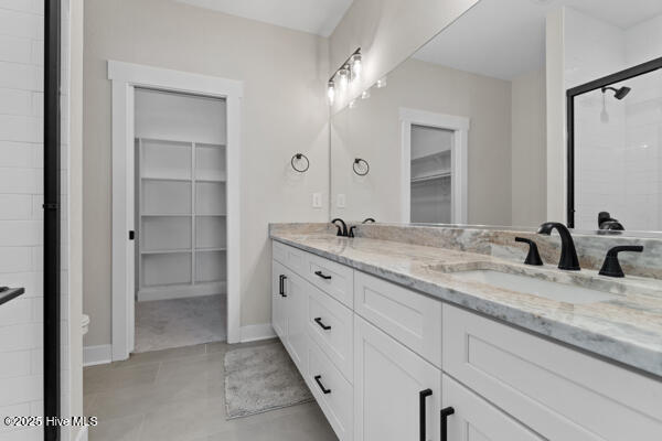 119 Bridgetowne Ave, Edenton, NC 27932 - bathroom featuring a spacious closet, double vanity, baseboards, and a sink