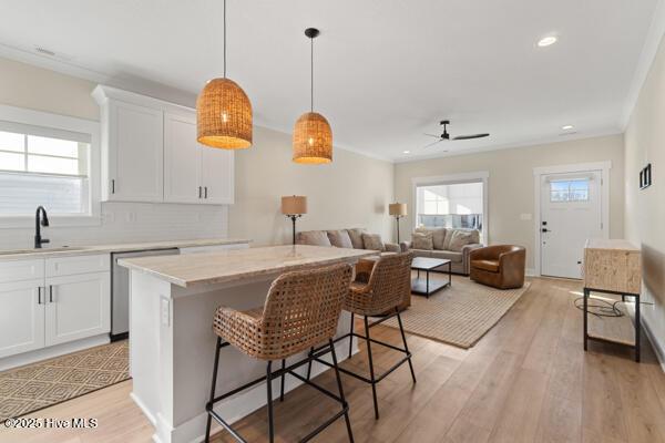 119 Bridgetowne Ave, Edenton, NC 27932 - kitchen with light countertops, a center island, a ceiling fan, stainless steel dishwasher, and a sink