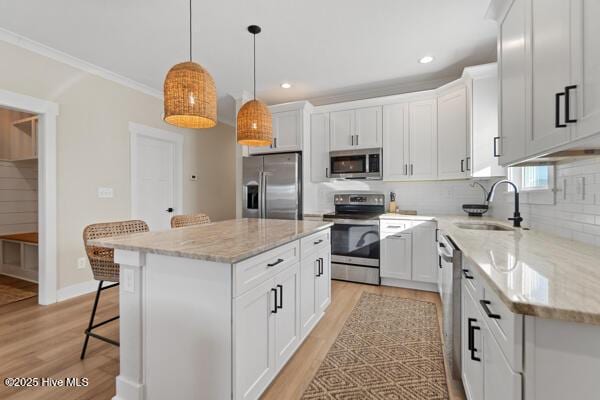 119 Bridgetowne Ave, Edenton, NC 27932 - kitchen with decorative backsplash, appliances with stainless steel finishes, a sink, light wood finished floors, and a breakfast bar area